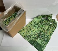 Box containing stacks of folded green dot bags and one bag opened to show full size