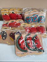 multiple sealed packs of assorted fruit-shaped loofah scrubbers displayed on table