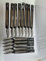 Nine long and five shorter Füri bread knives in sleeves