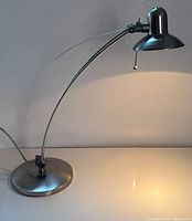 Full view of brushed nickel articulating desk lamp showing overall form