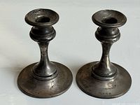 Front view of both tarnished sterling candlesticks