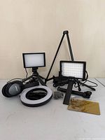 Full lot view with LED panels on tripods, ring light, Bose headphones, cords, gel sheet