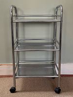 Front view of stainless steel 3-tier cart on casters