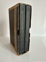 Two volumes in worn slipcase, spine view