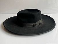 Side profile of black wool bolero hat showing flat crown, wide brim, hatband