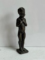 Front view of bronze boy figurine on base