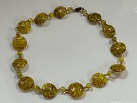 Full view of necklace laid flat showing bead pattern and clasp