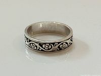 Ring angled view showing floral scroll design around band