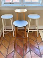 All four wooden stools grouped showing sizes and finishes