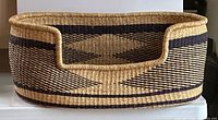 Oblique view showing full oval woven basket with contrasting pattern and cut-down front