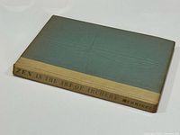 Front view of hardcover showing green boards, tan spine, title