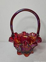 Full view of Fenton iridescent basket showing handle, ruffled rim and footed base