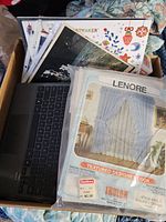 Box showing curtain panel package, keyboard, assorted prints