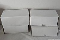 Four closed white cardboard boxes