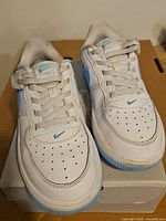 Front top view of both sneakers on box