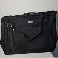 Front view of black Protocol garment bag with shoulder strap and exterior zip pocket