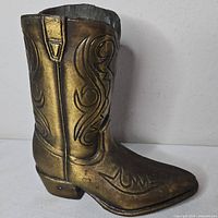 Side view of brass cowboy boot figurine showing scroll pattern