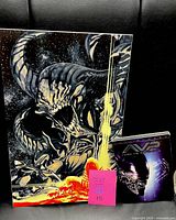 Front view of Alien art print and AVP DVD together