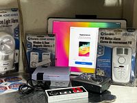 Group shot showing iPad, two Swann alarm packages, motion light alarm, mini NES console, controllers