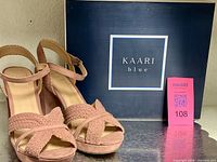 Sandals front view beside Kaari Blue box