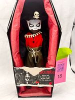 Doll in coffin with label visible