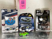 Overall lot showing three packaged diecast cars and one loose Hot Wheels