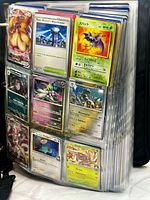 Open binder showing multiple 9-pocket pages filled with assorted Pokémon cards
