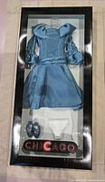 Front view of boxed blue outfit set showing dress, shoes, panties
