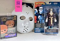 Lot overview showing Invisible Man figure, Wolf Man Pop Pin, white hockey mask
