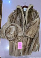 Coat and hat front view on hanger showing color and matching set