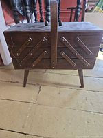 closed wooden cantilever sewing box on legs, front view