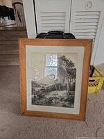 Framed black-and-white print leaning against wall