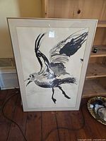 Front view of framed black and white bird painting showing full artwork, mat, and frame