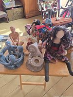 Overview of dolls and candle holders on small table