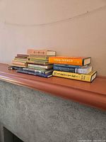 Full view of two stacks of assorted books on mantel
