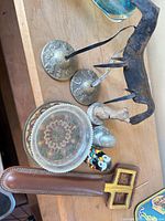 Assortment on shelf including stands, coaster, horse, owl, scissors in sheath and rusted hook tool