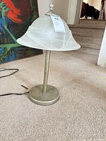 Side view of lamp showing metal base, stem, finial, and frosted glass shade