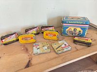 All eight tins arranged on wooden surface