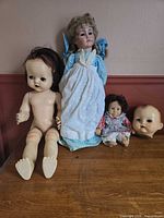 Group shot of all four vintage doll items on tabletop