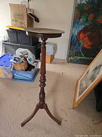 Full view of tall wooden plant stand on tripod base