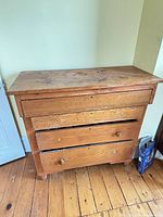 Front view of antique wooden dresser showing missing knobs and wear