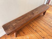 Full view of solid wood bench, top surface and legs visible