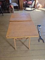 Two wooden folding TV tray tables shown open, view of tops and legs