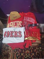 Overall lot overview showing four shirts and beanie