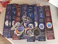 Nine Hosley zodiac incense packs and zodiac stickers displayed on table