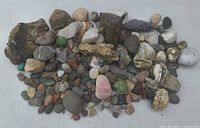 Full lot showing assorted rough and polished stones and mineral pieces laid out