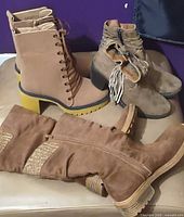Three pairs of brown/tan boots displayed together