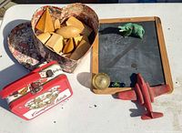 Group shot of all items: lunchbox, airplane, heart box of blocks, chalkboard with marbles and elephant