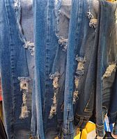 Ripped blue jeans hanging vertically showing distressing