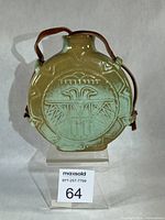 Front view of Frankoma Thunderbird canteen with Prairie Green glaze and leather strap